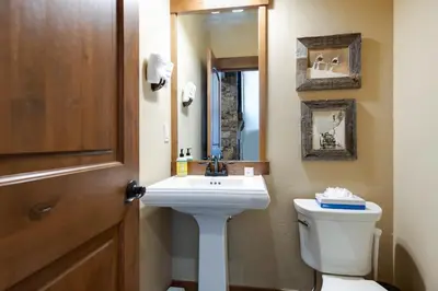 a bathroom with a sink and a toilet and a mirror at Ridgeview Court Townhome: Incredible Rooftop Deck in Frisco
