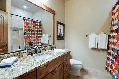 a bathroom with a sink and a toilet and a mirror at Ridgeview Court Townhome: Incredible Rooftop Deck in Frisco