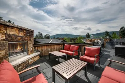 a patio with two chairs and a fireplace at Ridgeview Court Townhome: Incredible Rooftop Deck in Frisco