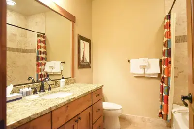 a bathroom with a sink and a toilet and a mirror at Ridgeview Court Townhome: Incredible Rooftop Deck in Frisco