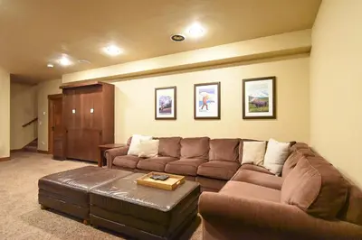 a living room with a brown couch and a table at Ridgeview Court Townhome: Incredible Rooftop Deck in Frisco