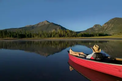 a red boat on a lake with mountains in the background at Tarn Landing Condo: Access To All Summit Resorts in Frisco