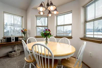 a dining room with a wooden table and white chairs at Tarn Landing Condo: Access To All Summit Resorts in Frisco
