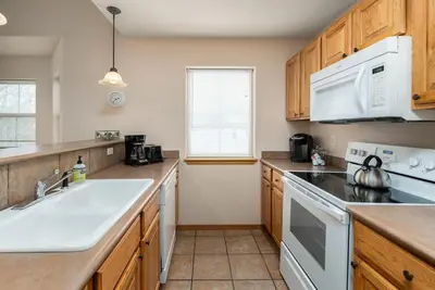 a kitchen with white appliances and wooden cabinets at Tarn Landing Condo: Access To All Summit Resorts in Frisco