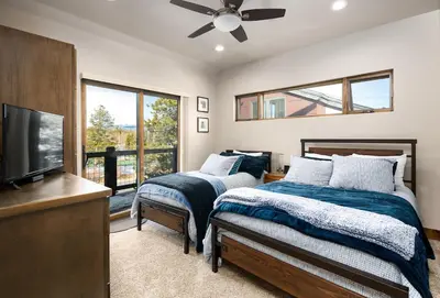 a bedroom with two beds and a flat screen tv at Deming Crossing Duplex: Downtown Frisco Chic in Frisco