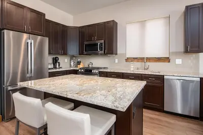 a kitchen with a granite counter top and stainless steel appliances at Deming Crossing Duplex: Downtown Frisco Chic in Frisco