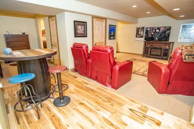 a living room with red chairs and a table at Bear Creek Mining Lodge: Mountain Style, Hot Tub in Breckenridge Airport