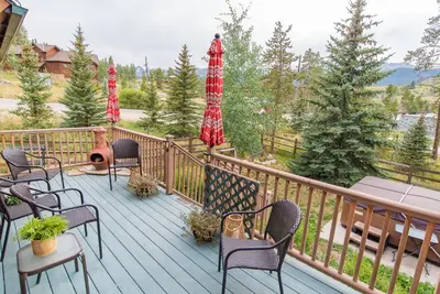 a deck with chairs and umbrellas on a balcony at Bear Creek Mining Lodge: Mountain Style, Hot Tub in Breckenridge Airport