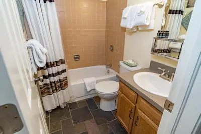 a bathroom with a tub and a toilet and a sink at Mountainside Snowview Condo : Cool Frisco Location in Frisco