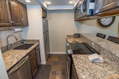 a small kitchen with a sink and a stove at Mountainside Snowview Condo : Cool Frisco Location in Frisco