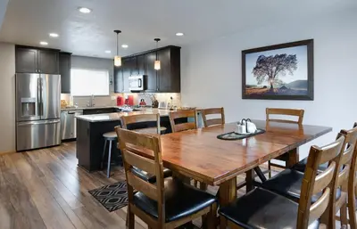 a kitchen and dining room with a wooden table and chairs at Blue Granite Off Main Townhome: Updated, Great Location in Frisco