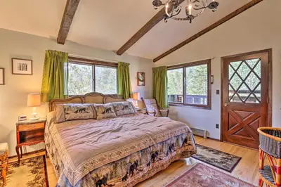 a bedroom with a large bed and windows at Walk to Town Updated Frisco Cabin with 2 Decks! in Frisco
