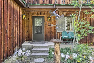 a wooden house with a door and two chairs at Walk to Town Updated Frisco Cabin with 2 Decks! in Frisco