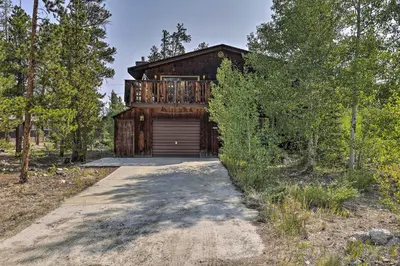 a wooden house with a garage in the woods at Walk to Town Updated Frisco Cabin with 2 Decks! in Frisco