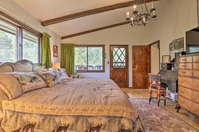 a bedroom with a large bed and a dresser and windows at Walk to Town Updated Frisco Cabin with 2 Decks! in Frisco