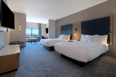 a hotel room with two beds and a flat screen tv at Fairfield by Marriott Inn & Suites Denver Airport at Gateway Park in Denver