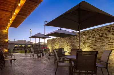 a patio with tables and chairs with umbrellas at Fairfield by Marriott Inn & Suites Denver Airport at Gateway Park in Denver