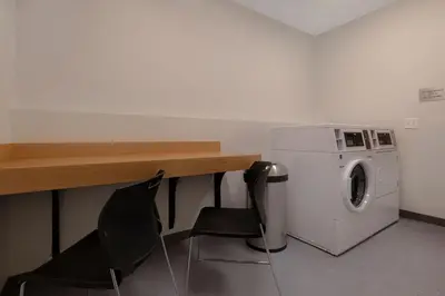 a laundry room with a washing machine and two chairs at Fairfield by Marriott Inn & Suites Denver Airport at Gateway Park in Denver