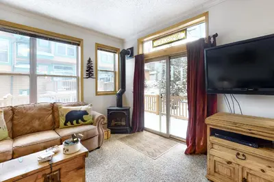 a living room with a couch and a flat screen tv at Saddle Ridge in Silverthorne