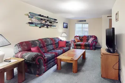 a living room with a couch and a chair and a tv at Saddle Ridge in Silverthorne