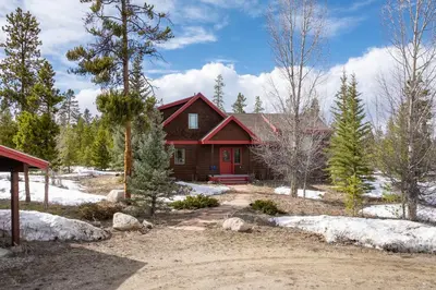 a red house with a red door in the snow at 383 County Road 508 by Stay Winter Park in Fraser