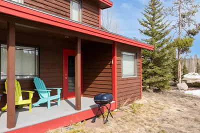 a house with two chairs and a grill on the porch at 383 County Road 508 by Stay Winter Park in Fraser