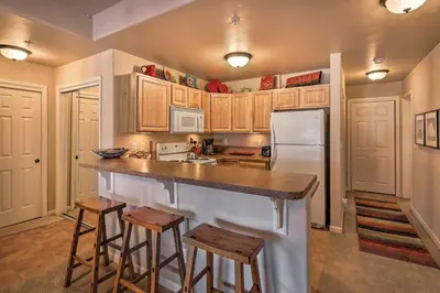 a kitchen with a counter and a white refrigerator at Fraser Condo 5 Miles to Winter Park Resort! in Fraser