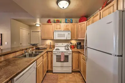 a kitchen with wooden cabinets and a white refrigerator at Fraser Condo 5 Miles to Winter Park Resort! in Fraser