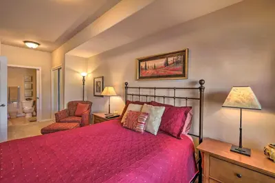a bedroom with a red bed and a chair at Fraser Condo 5 Miles to Winter Park Resort! in Fraser