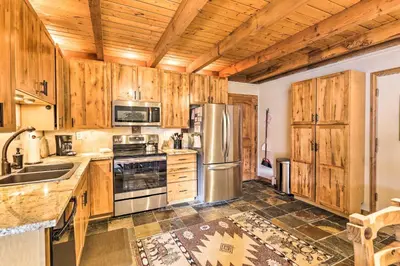 a kitchen with wooden cabinets and stainless steel appliances at Ski and Hike Mtn-View Condo in Silverthorne! in Silverthorne