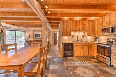 a kitchen with wooden cabinets and a large wooden table at Ski and Hike Mtn-View Condo in Silverthorne! in Silverthorne