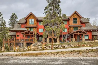 a large red house with trees in front of it at The Seasons 1818 condo in Keystone
