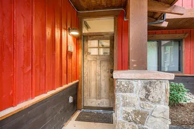 a wooden door of a red building with a stone pillar at The Seasons 1818 condo in Keystone