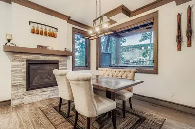 a dining room with a fireplace and a wooden table and chairs at The Seasons 1818 condo in Keystone