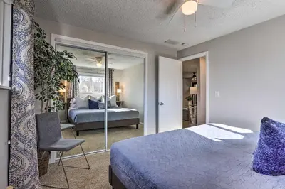 a bedroom with a bed and a chair and a mirror at Duplex with Private Yard 3 Mi to Downtown Loveland! in Loveland