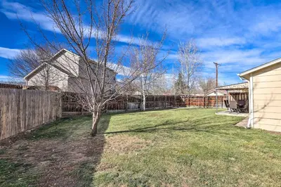 a yard with a tree and a fence at Duplex with Private Yard 3 Mi to Downtown Loveland! in Loveland
