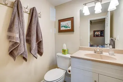 a bathroom with a toilet and a sink and a mirror at 2 Blocks to Main St Downtown Frisco Condo! in Frisco