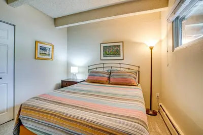 a bedroom with a bed and a lamp and a window at 2 Blocks to Main St Downtown Frisco Condo! in Frisco