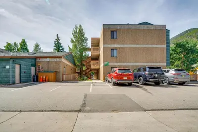 a parking lot with cars parked in front of a building at 2 Blocks to Main St Downtown Frisco Condo! in Frisco