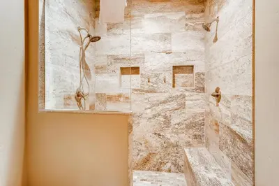 a bathroom with a shower with a stone wall at Estates on Galena #8 townhouse in Frisco