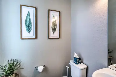 a bathroom with two pictures of leaves on the wall at Ski and Hike Home with Hot Tub and Gas Grill in Granby in Granby