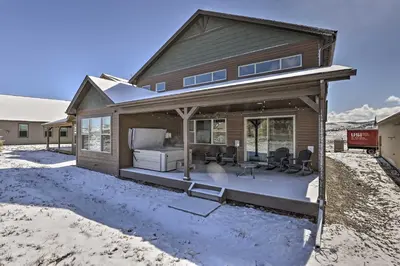 a house with a large porch with a bed at Ski and Hike Home with Hot Tub and Gas Grill in Granby in Granby