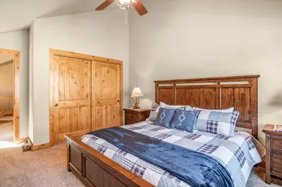 a bedroom with a large bed with a wooden headboard at River Rock Retreat -- EV #6032 condo in Estes Park