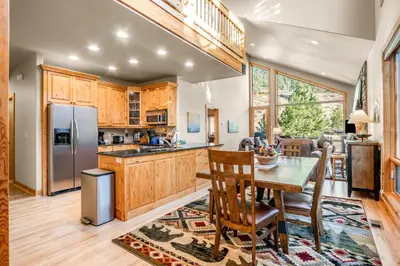 a kitchen and dining room with a table and chairs at River Rock Retreat -- EV #6032 condo in Estes Park