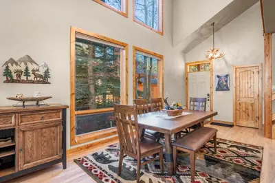 a dining room with a wooden table and chairs at River Rock Retreat -- EV #6032 condo in Estes Park