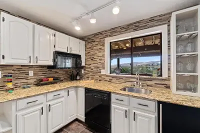 a kitchen with white cabinets and a black dishwasher at Outstanding Home, Incredible Views, Near Reservoir in Fort Collins