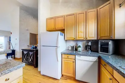a kitchen with a white refrigerator and wooden cabinets at Prospector Village 105C in Silverthorne