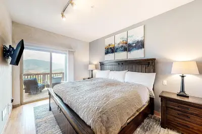 a bedroom with a bed and a large window at Prospector Village 105C in Silverthorne