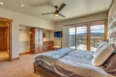 a bedroom with a large bed and a balcony at Mountain Adventure Home Base - Ski, Hike and Chill! in Fraser