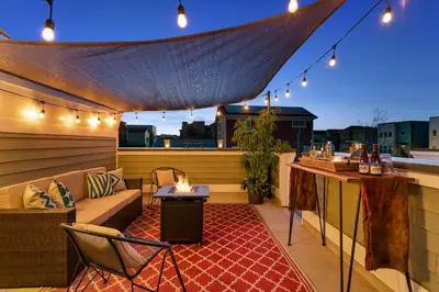 a patio with a couch and a table on a roof at Old Town North Jewel! Near Breweries and River! in Fort Collins